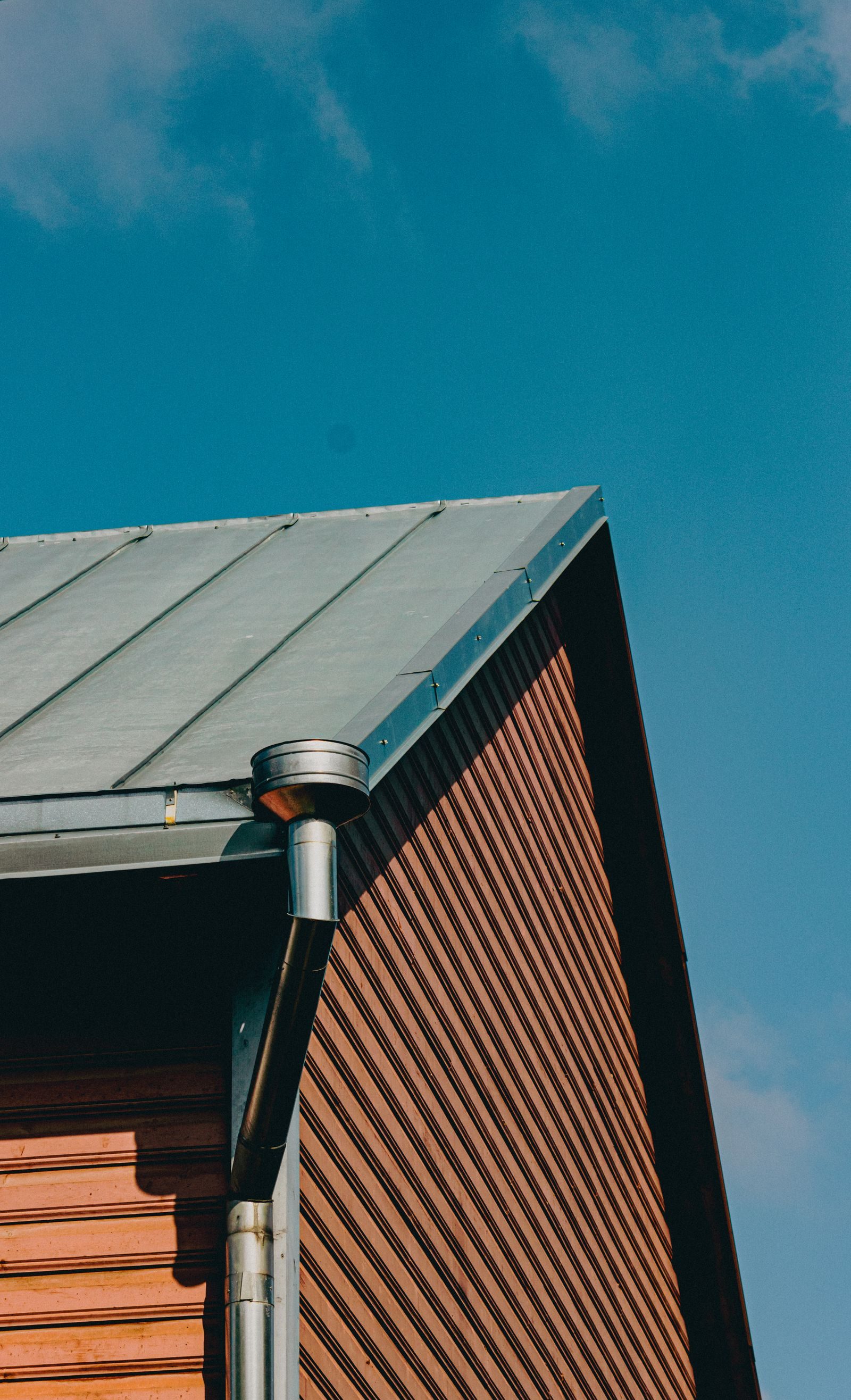 Roofline of a family house with gutters against a bright sky